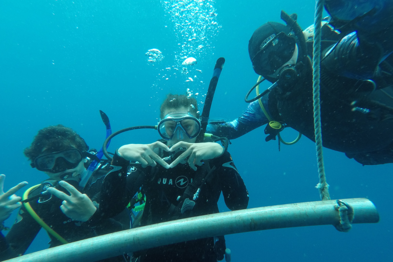 Three male scuba divers looking at the camera