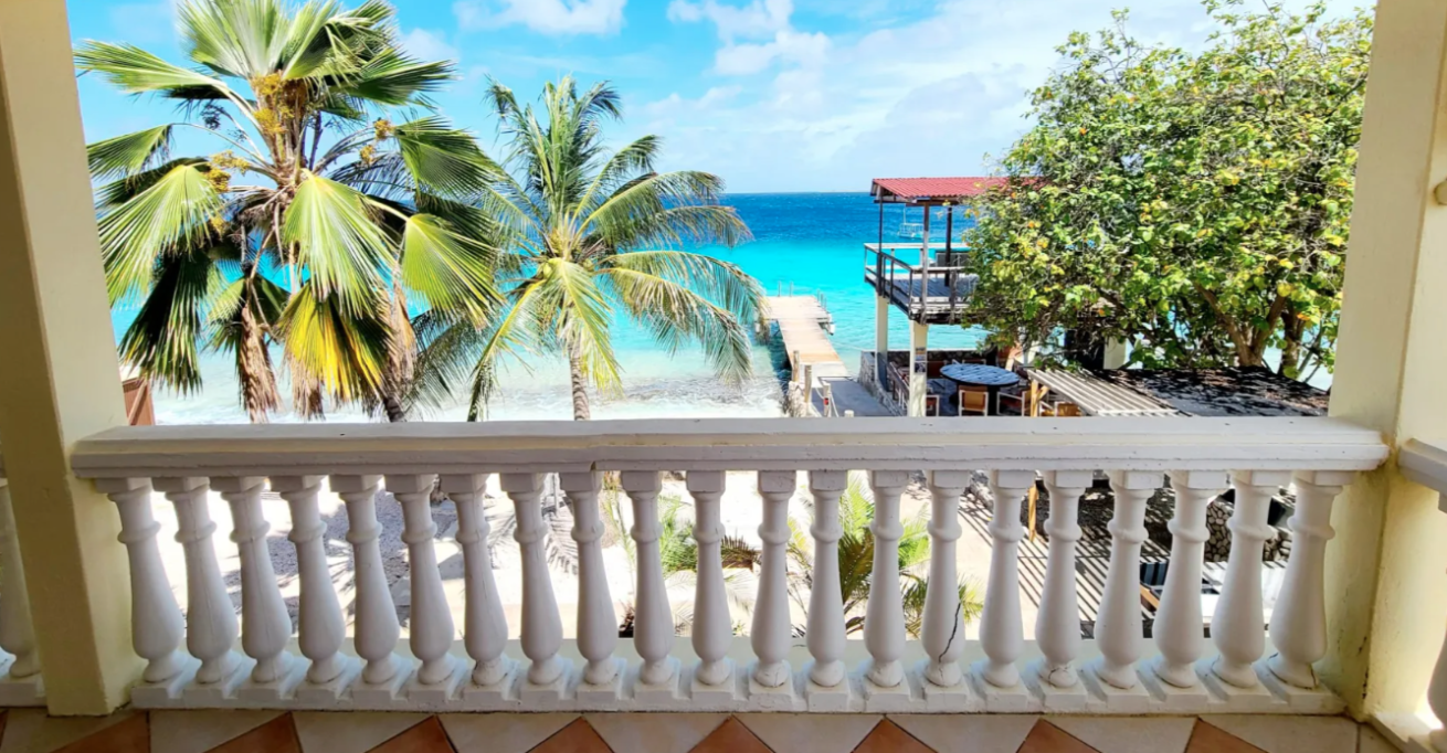 Balcony view of palm trees and beach