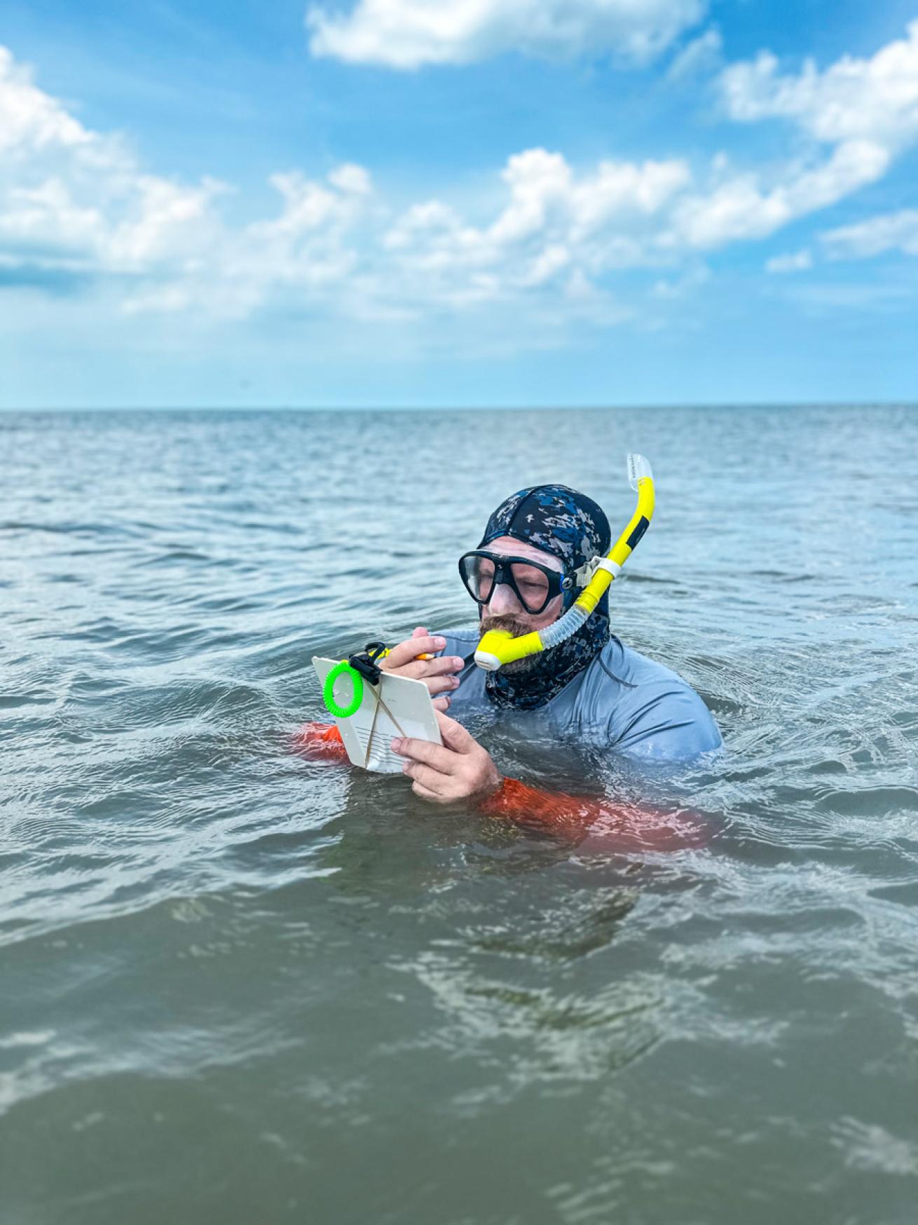 A test diver takes notes on a snorkel.