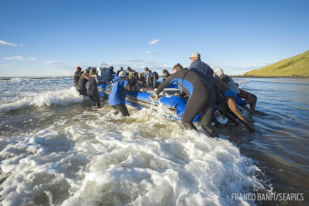 Divers entering the water with small boat