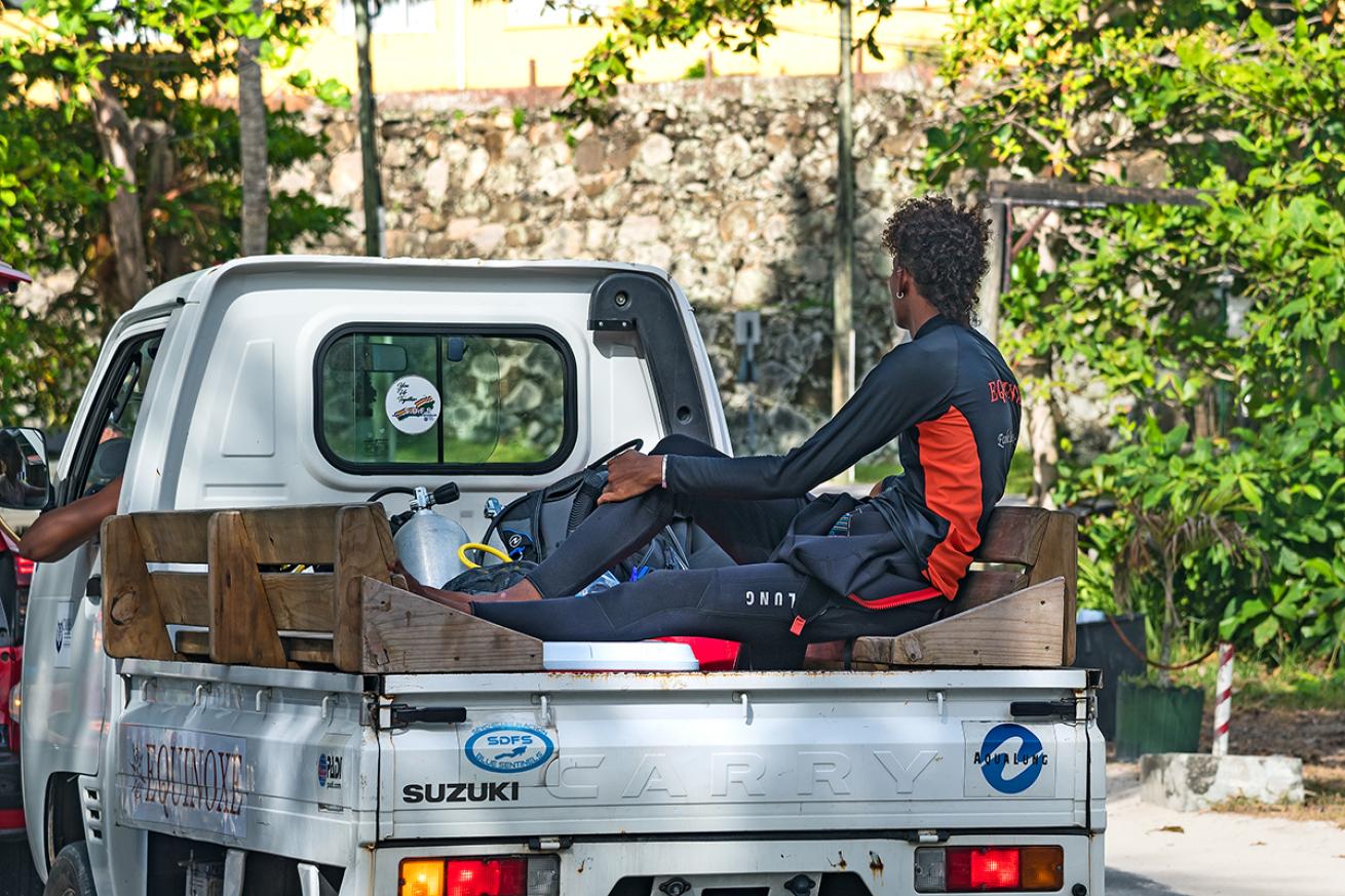 Scuba diver rides in back of car