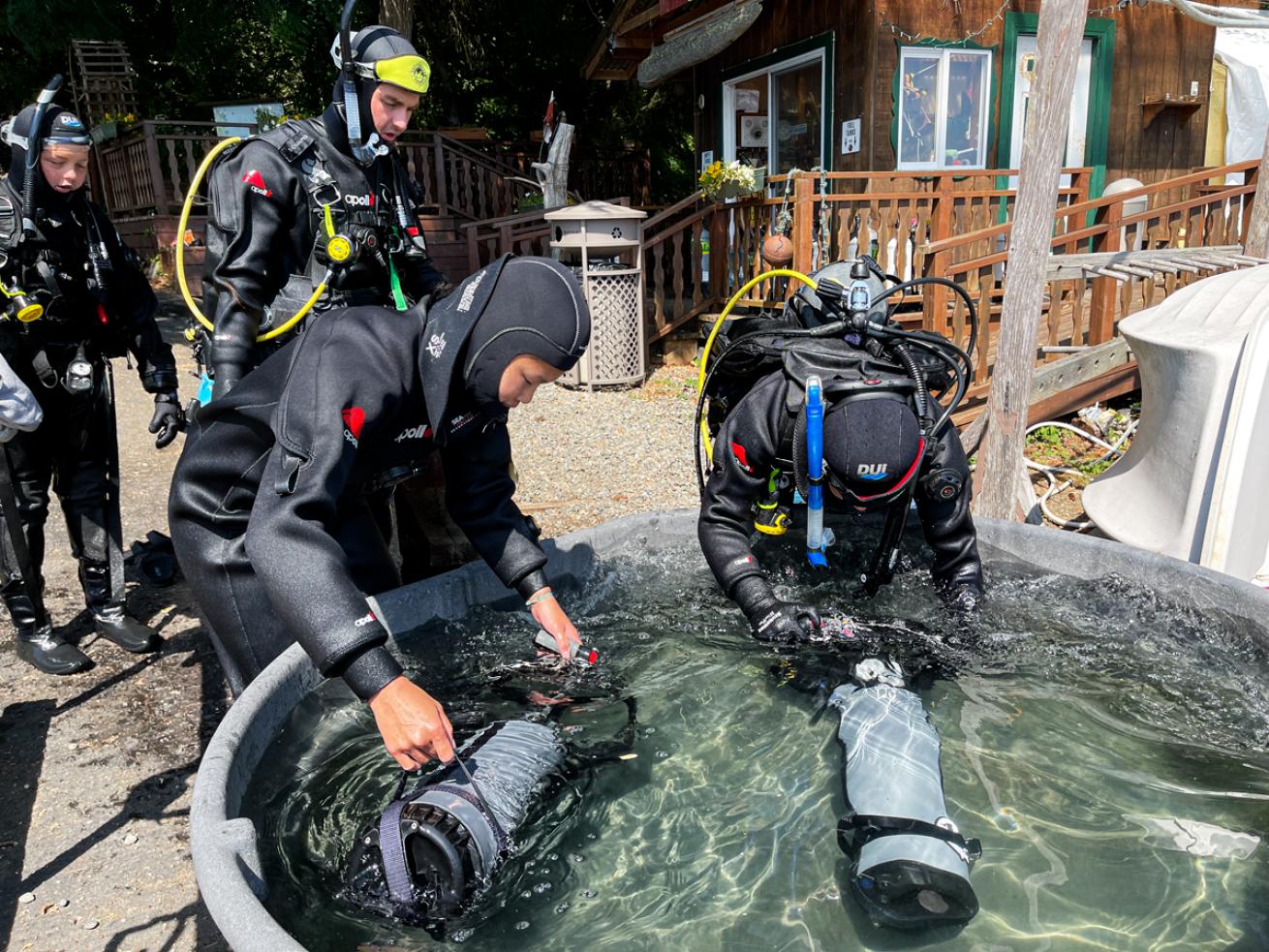 Divers rinsing DPVs
