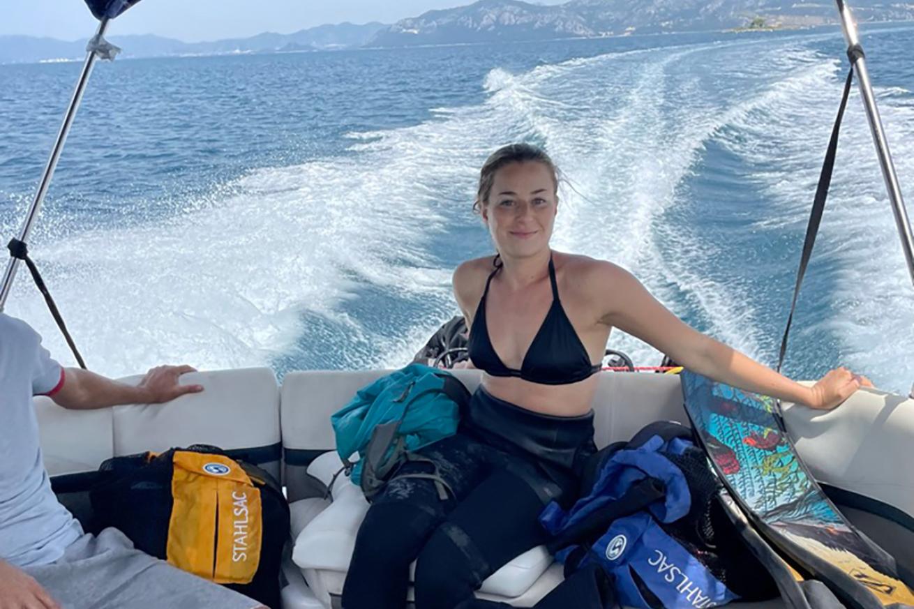 Partially-geared up diver on speed boat