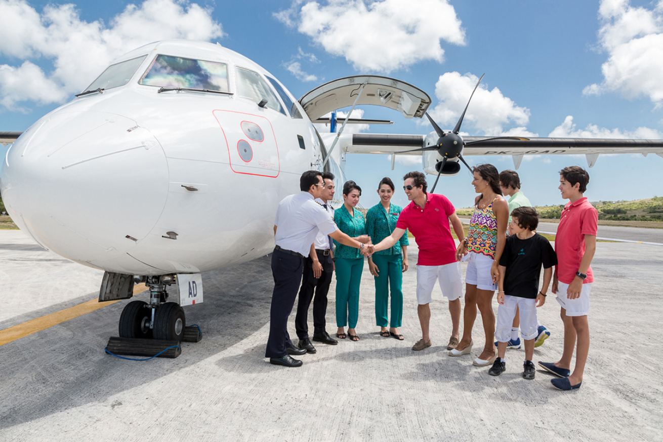 A group of people in front of a plane