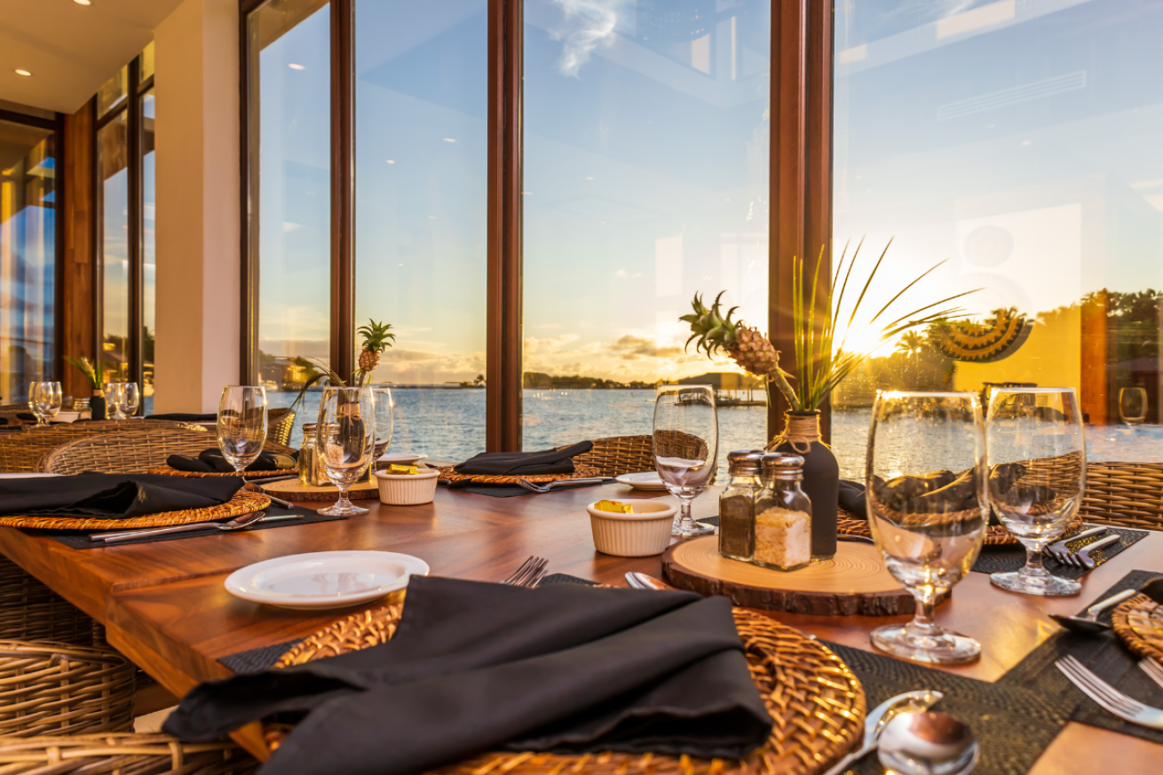 A table with plates and glasses on it overlooking the water