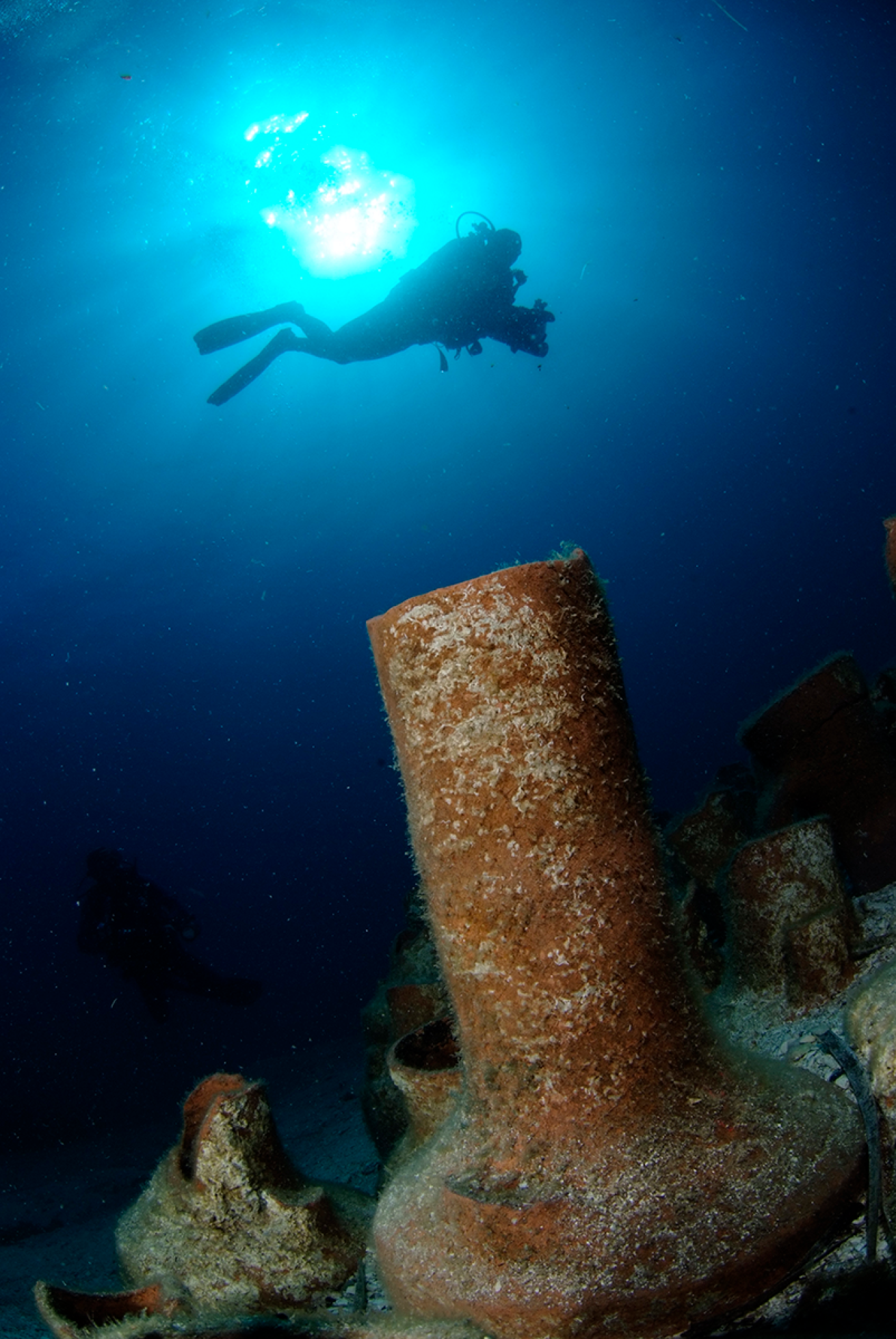 Diver swimming above amphores.