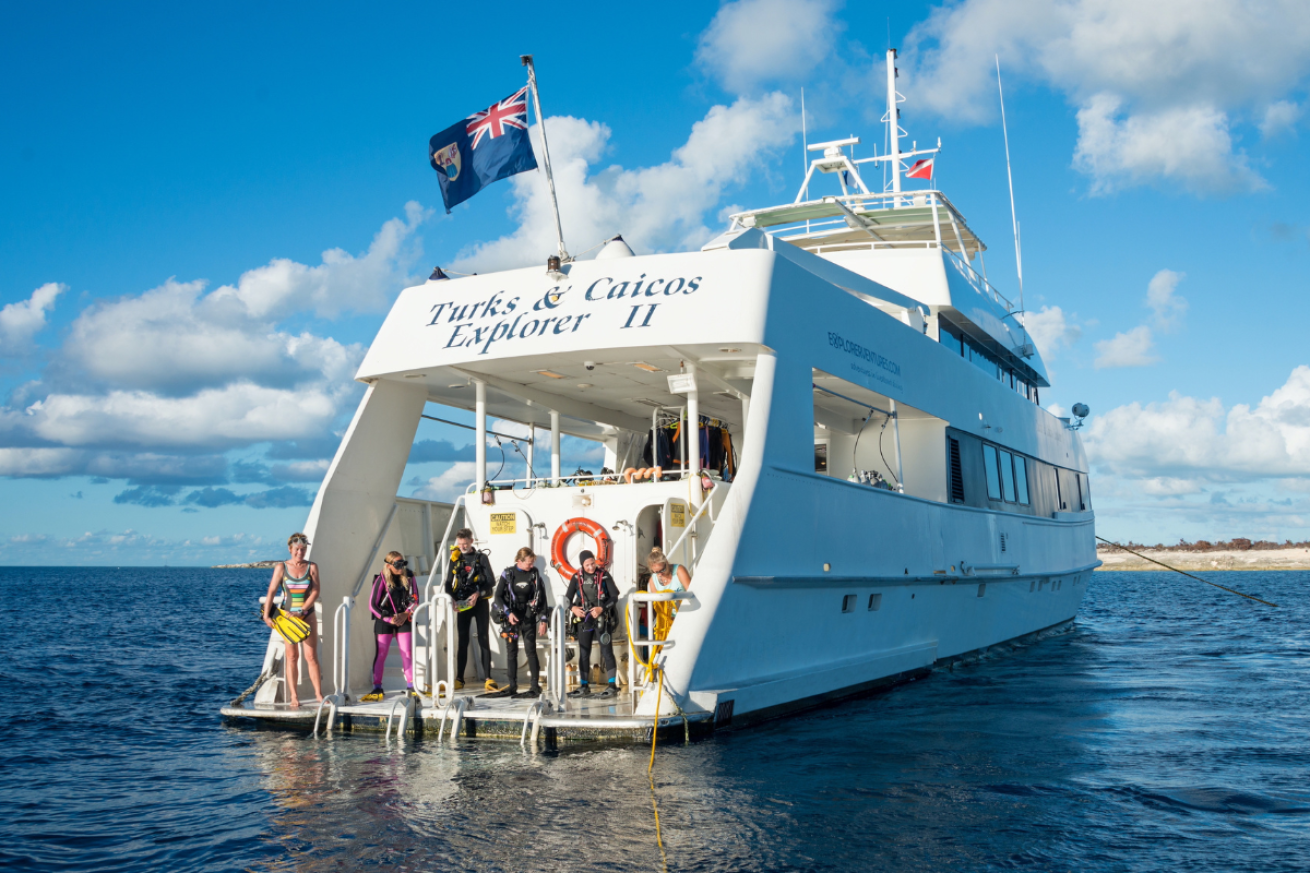 Large boat in the water with scuba diving standing on the back