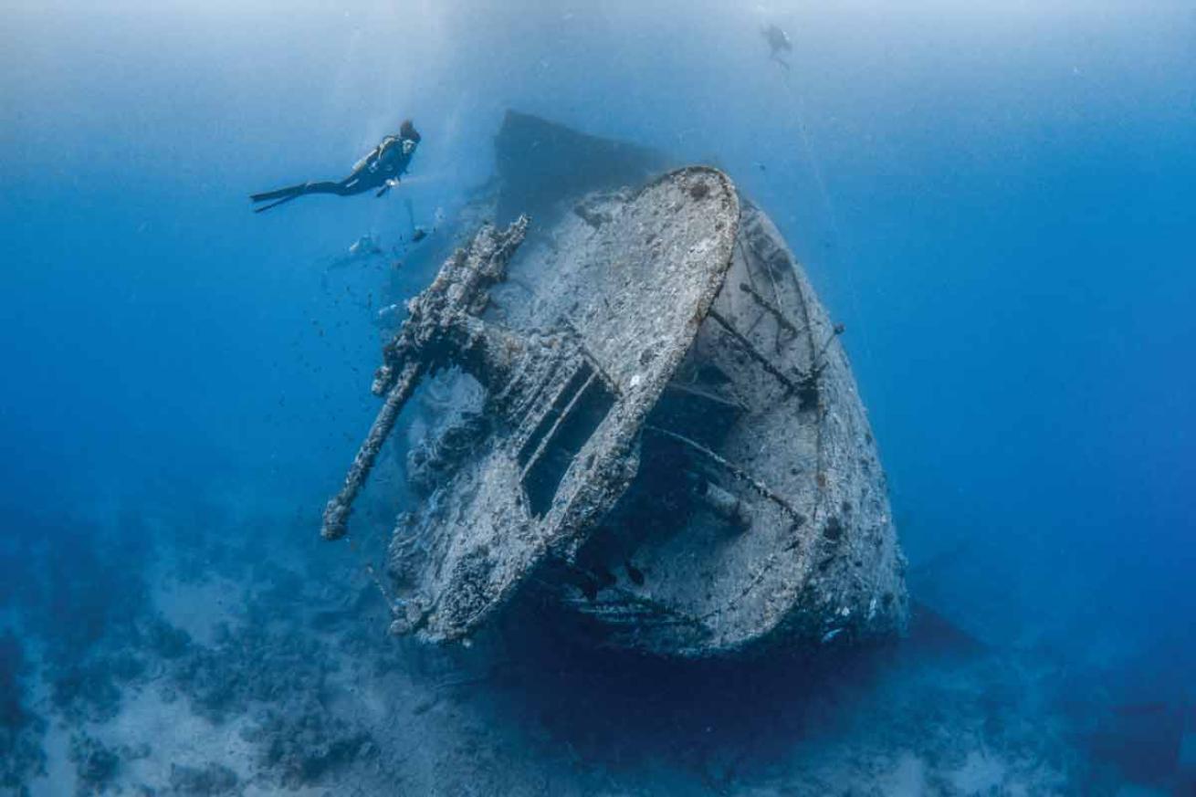 Thistlegorm wreck with a scuba diver swimming above it