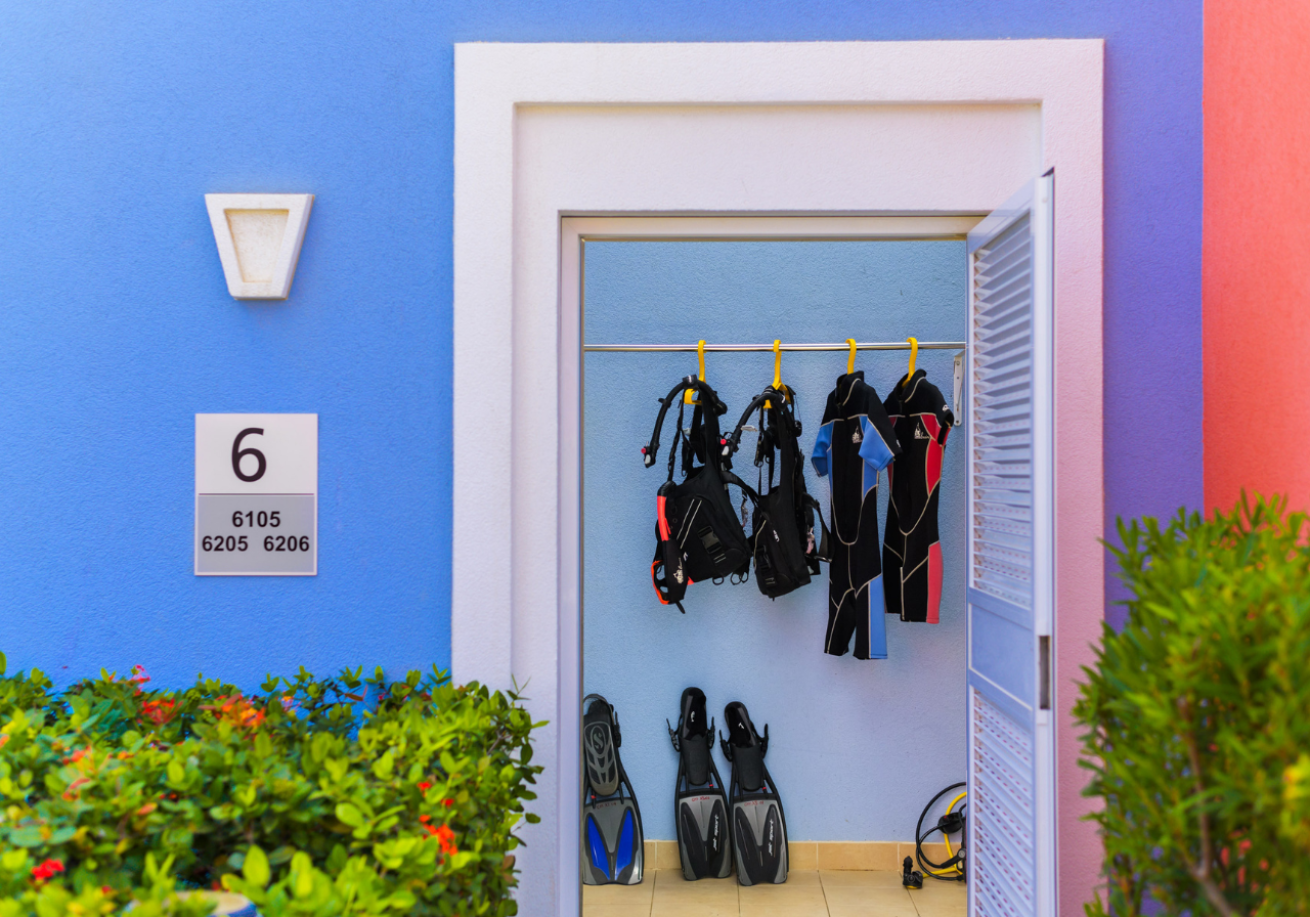 A door with a blue wall and a blue wall with scuba gear from it