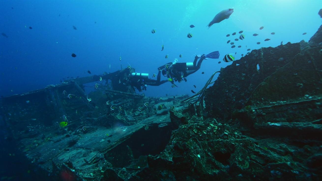 Scuba divers exploring a wreck in Oahu.