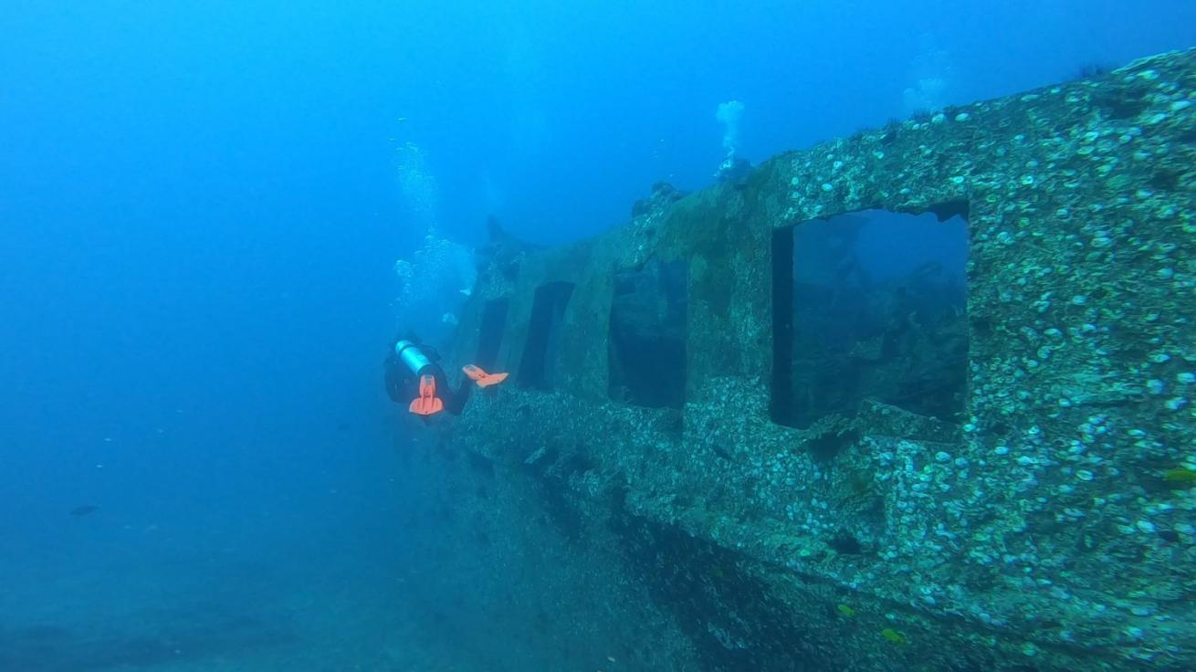 A scuba diver exploring a ship wreck in Hawaii.
