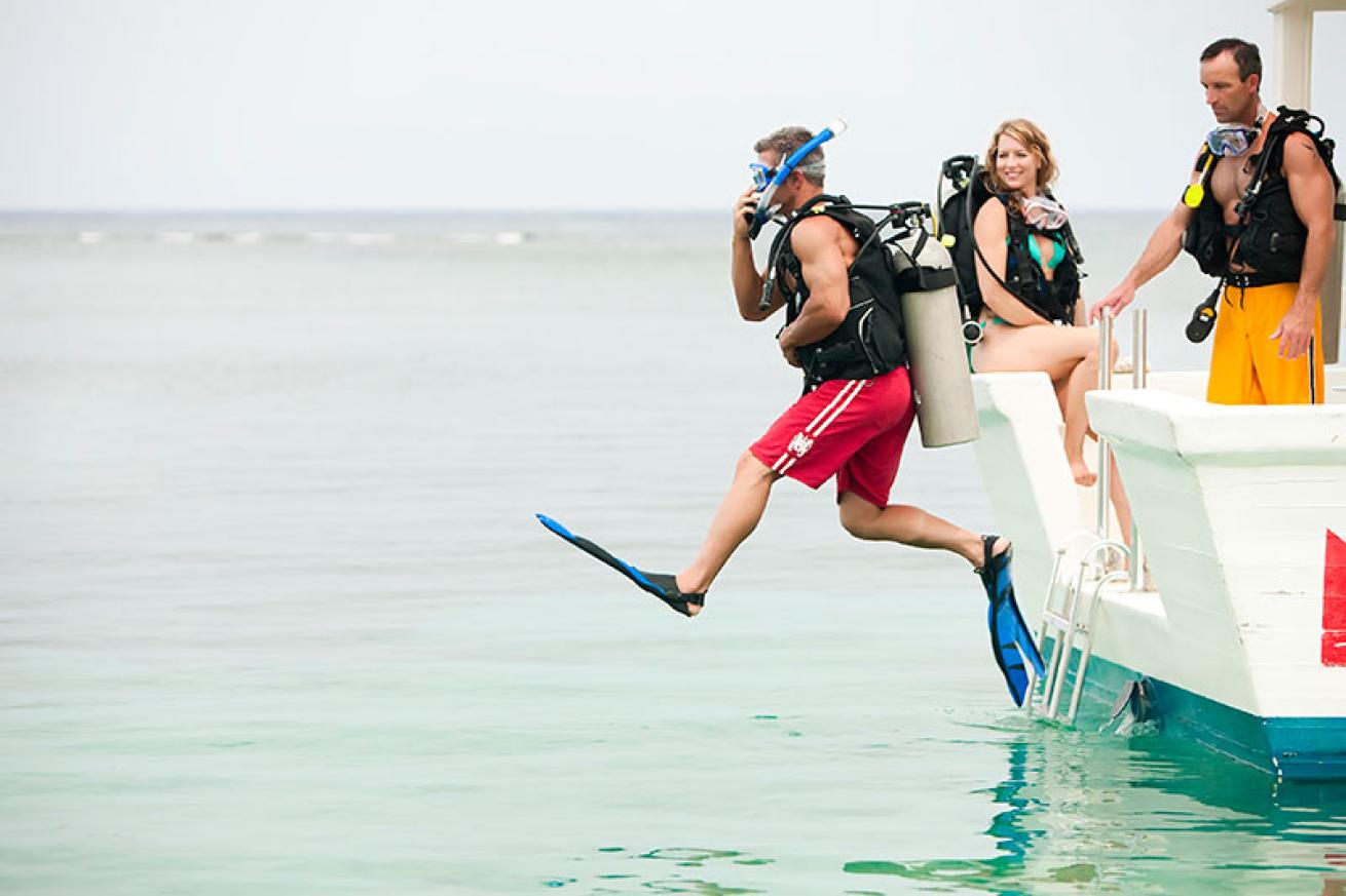 Scuba diver giant-striding off dive boat