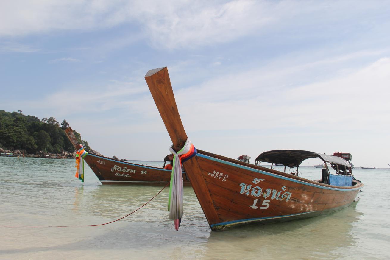 Long-tail boats on a beach in southern Thailand.