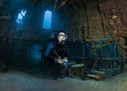 Scuba diver exploring the wreck of the Doc Poulson in Grand Cayman